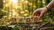 © MD BILLAL MIA - Hand places eco-friendly house symbol on wooden blocks with earth, leaf, recycle icons in forest