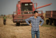 © Budimir Jevtic - Farmer standing in front of combine harvester