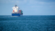 © Travel 'n' Lifestyle - View of a large container ship carrying colorful cargo across the calm blue waters of the Atlantic Ocean under a cloudy sky Lisbon, Lisbon, Portugal.