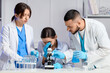 © Pixel-Shot - Young chemists examining water samples while looking through microscope in laboratory
