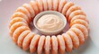 © G_Kawi - Garniture de rondelles de crevettes avec sauce, présentée en apéritif sur une assiette blanche