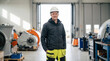 © ViskBx - Portrait of a professional technician wearing a hard hat and work clothes, standing in a modern industrial workshop or factory facility