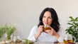 © SplitStudio - Woman enjoying herbal tea with fresh herbs and plants on table