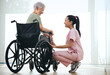 © peopleimages.com - Nurse, old woman and laugh in wheelchair at window in morning, healing and funny story in retirement home. Caregiver, patient and elderly person with disability, joke and rehabilitation at house