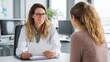 © Peakstock - Personalized exercise plan discussion in a modern office setting between two women