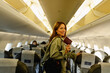 © SISMIZ - Woman traveling on airplane holding passport and smiling