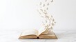 © Interista - Open book with pages transforming into white butterflies taking flight, surreal education concept on white background with copy space
