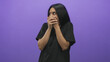 © Krakenimages.com - Woman hands covering mouth gesture in studio with black tshirt and purple backdrop, standing in a startled pose conveying silence and concealment; surprise secrecy.