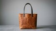 © Bangga - Brown leather tote bag features distressed tan leather and dark handles in a clean studio setting. This image is ideal for high-end boutique branding and leather goods advertising.