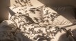 © ABDUL - 'Cozy unmade bed with white crumpled sheets and pillows, morning sunlight casting soft tree shadows across the bedding, warm and peaceful bedroom scene'