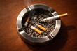 © AkuAku - Top view of a metal ashtray resting on a brown wood surface