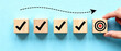 © Mamer - Achieving business goals by completing tasks in a strategic and organized manner, represented by wooden blocks with checkmarks and a bullseye