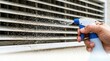 © Nataly - Cleaning air conditioner vents with spray bottle, ensuring effective airflow and dust reduction for optimal cooling performance.