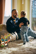 © Maskot - Happy father playing with daughter in living room at home