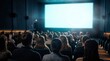 © Masque - A large movie audience seated in a modern cinema facing a bright illuminated blank screen.