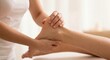 © whitestorm - Close-up of a therapist's hands gently massaging a person's foot and ankle for relaxation and healing.
