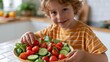 © AZ Studio - Smiling young boy happily preparing a fresh salad with cherry tomatoes and cucumbers