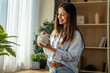 © Miljan Živković - Woman smiling while putting money into piggy bank