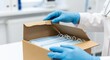 © altaf - Medical professional in blue gloves opening a box of surgical face masks
