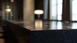 © Alesia - Dark granite countertop with a sparkling finish featuring a blurred modern indoor background with warm lighting and a window, creating a sophisticated and elegant atmosphere