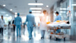 © CStock - Blurred scene in a hospital with medical staff assisting a patient on a stretcher, emphasizing healthcare environment.