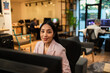 © Davor - Smiling professional woman working at computer in modern coworking office