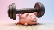 © Ankit - A distressed pink piggy bank labeled savings struggling under the weight of a heavy metal debt dumbbell barbell
