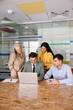 © fizkes - Diverse businesspeople reviewing online project, planning business strategy, engage in collaborative meeting, teamwork using laptop in corporate office. Team communication, professional cooperation