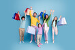 © deagreez - Happy family shopping together: parents and children holding colorful bags, cheering and jumping against a blue background for retail celebration and joyful family fun