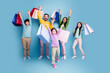 © deagreez - Happy family of five celebrating a shopping day with colorful bags, parents and children smiling and jumping together on a bright blue background