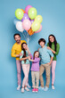 © deagreez - Happy family portrait with parents and children holding colorful balloons for celebration and birthday party
