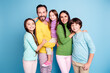 © deagreez - Happy smiling family portrait with parents and three children embracing against a bright blue background, showing togetherness, love and modern family lifestyle