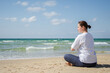 © Юлия Завалишина - Yoga calm mindfulness meditation. Young healthy woman practicing yoga on beach. Woman sitting in lotus pose meditating relaxing connection with nature by the sea. Girl doing breathing practice