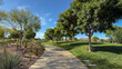 © HO-HO - Vibrant view of lush green hills and manicured lawns in a public park. Featuring winding walking paths, decorative shrubs, and leafy trees under a clear blue sky. Peaceful summer day atmosphere.