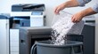 © Stitch - Office worker emptying a bin of shredded white paper into a trash can