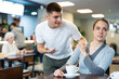 © JackF - Girl rejects guy. Young man violates personal boundaries of female cafe visitor, distracts her. Girl pushes away annoying guy