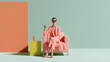 © imstock - Una mujer vestida con un traje de color rosa sentada en un sofá
