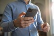 © Sadia217 - Person using smartphone in indoor casual setting with focused expression and natural light.