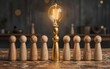 © joeycheung - Wooden figures one golden gaze upward at a glowing light bulb above