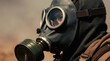 © Maryna - Person wears gas mask outdoors. Protective mask covers face, filters air. Person looks serious wearing protective gear. Dry background hints at danger.