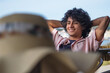 © tetxu - Smiling young man relaxing on the terrace of an outdoor bar