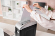 © Pixel-Shot - Female hands destroying document in shredder on desk at office