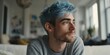 © chelmicky - Young man with blue hair contemplating indoors