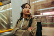 © Jacob Lund - Woman with headphones commuting on a city metro