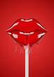 © Nokkz - Glossy red lip-shaped lollipop melting and dripping on a white stick against a vibrant red background.