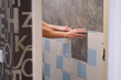 © smile35 - A man glues wall panels onto old tiles. A quick and affordable renovation
