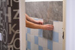 © smile35 - A man glues wall panels onto old tiles. A quick and affordable renovation