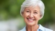 © buraratn - Cheerful senior woman smiling outdoors with natural green background, showcasing joy and happiness in a bright, sunny setting, radiating warmth and positivity