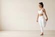 © spyrakot - Active woman in clean white workout clothes stretching indoors