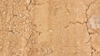 © Gulmira Uatkhanova - Texture of a dry dirt road with cracks and dust, unpaved rural path in arid region, top view of parched ground surface